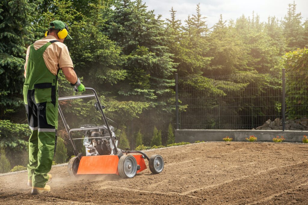 Professional Gardener Aerating Backyard Lawn